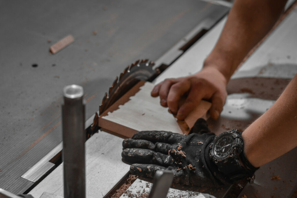 man mechanically cutting wood