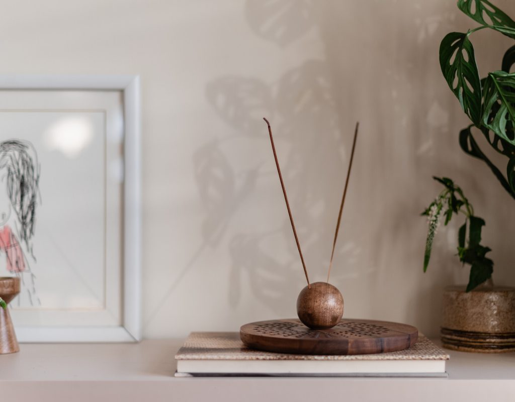 Wooden incense holder on a shelf with incense sticks