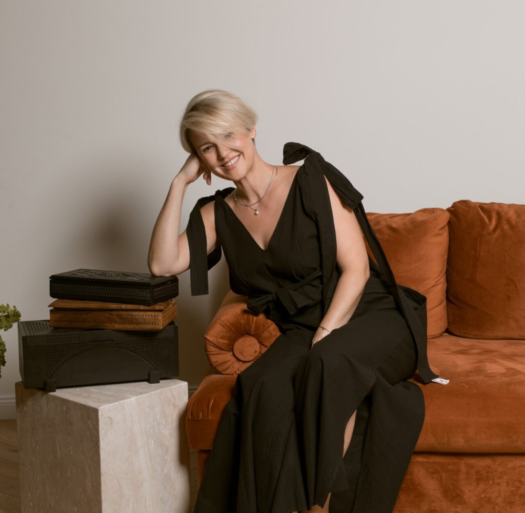 Jasmina Dizdarević in a black dress sitting on couch