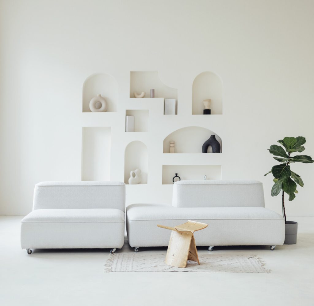 stylish bright interior. A white wall with niches. Vases, stones